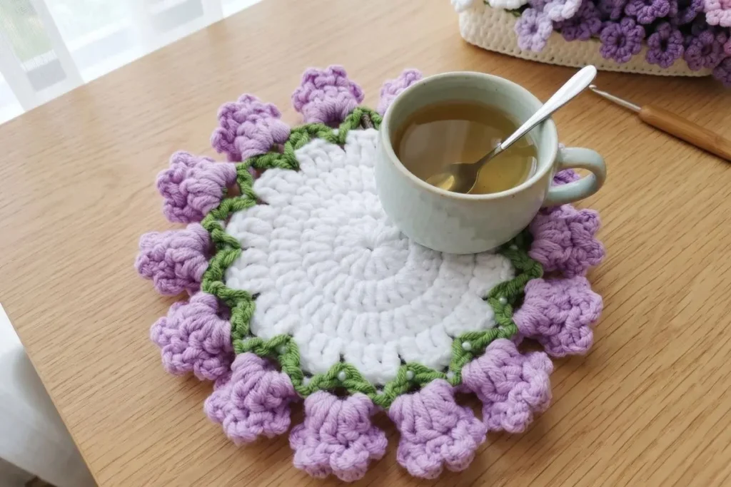 Crochet Lavender Bell Flower Doily Pattern with lavender flowers and green leaf border worked in cotton yarn