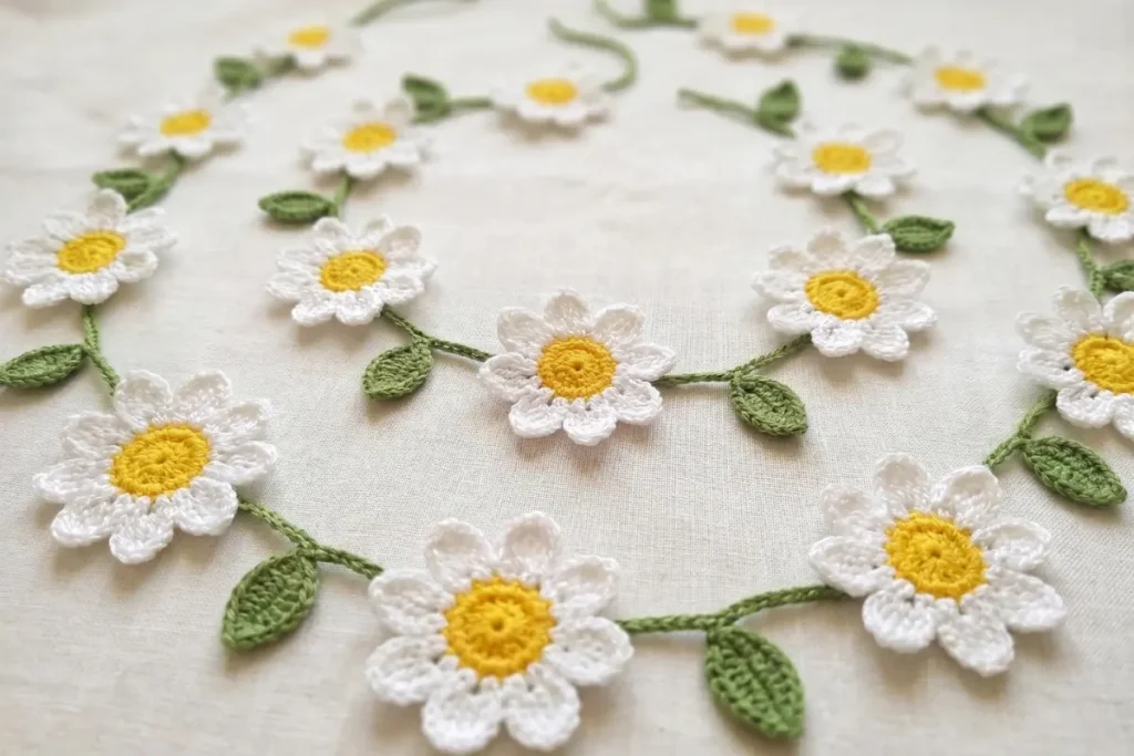 Daisy Garland Crochet Pattern with crochet daisies, green leaves, and decorative vine